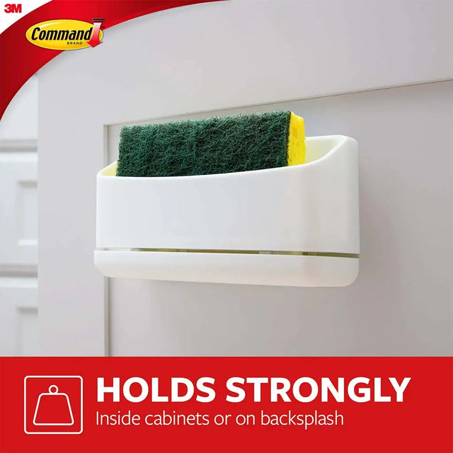 White sponge holder with a green sponge inside, mounted on a white wall, featuring 3M Command brand.