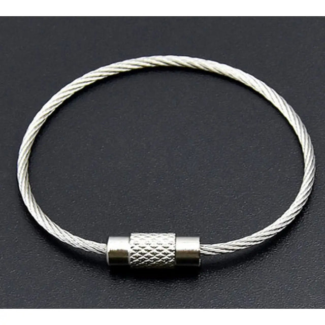 Silver cable bracelet with a metal clasp on a dark background