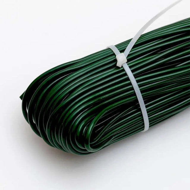 Coiled green wire tied with a white cable tie on a white background