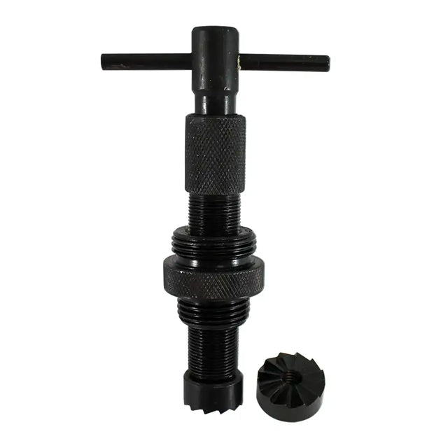 A black metal threaded tool with a T-handle on top and a separate small circular component placed beside it, shown on a plain white background.