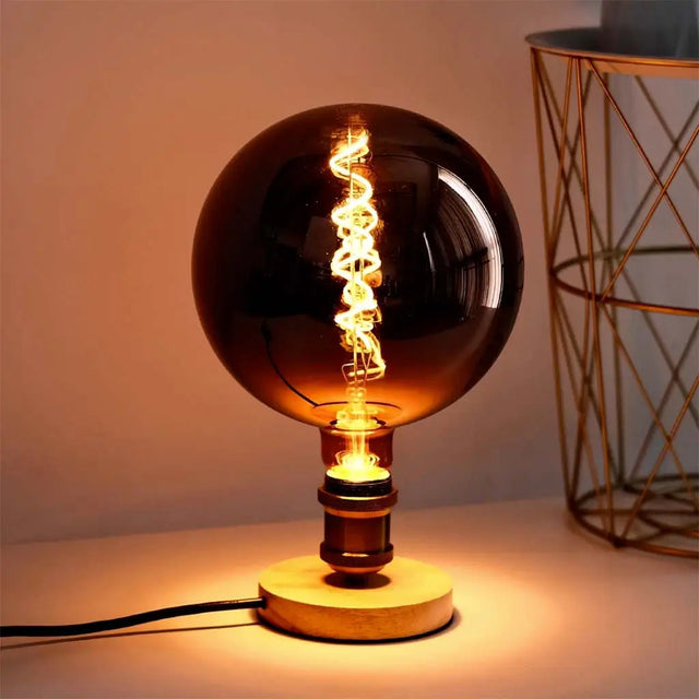 Decorative light bulb with wooden base on a neutral background