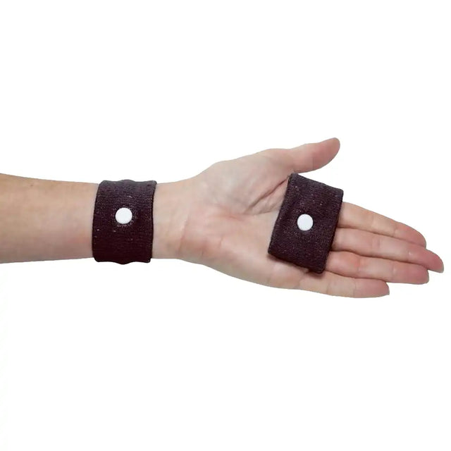 Hand wearing a brown wristband with a small circular hole on a white background