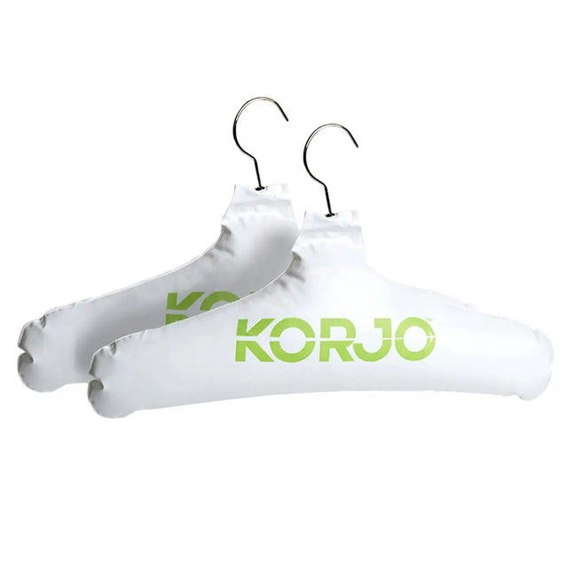 Two white hangers with 'KORU' branding on a white background
