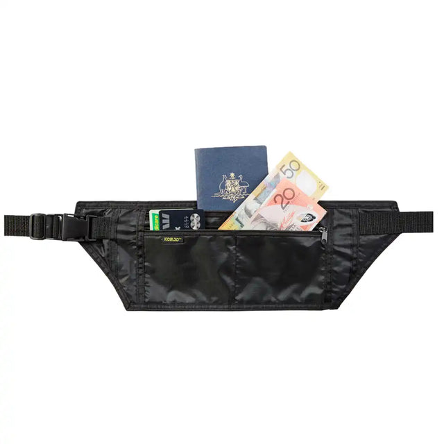Black waist bag with travel items including a passport and money on a white background