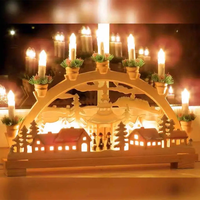 Decorative candle arch with lit candles and small plants on a blurred background
