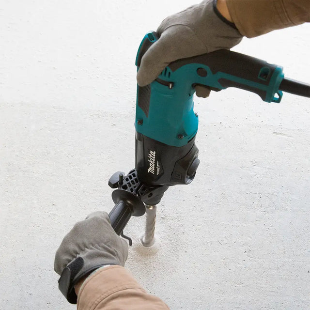 Person using a Makita nail gun on a white surface