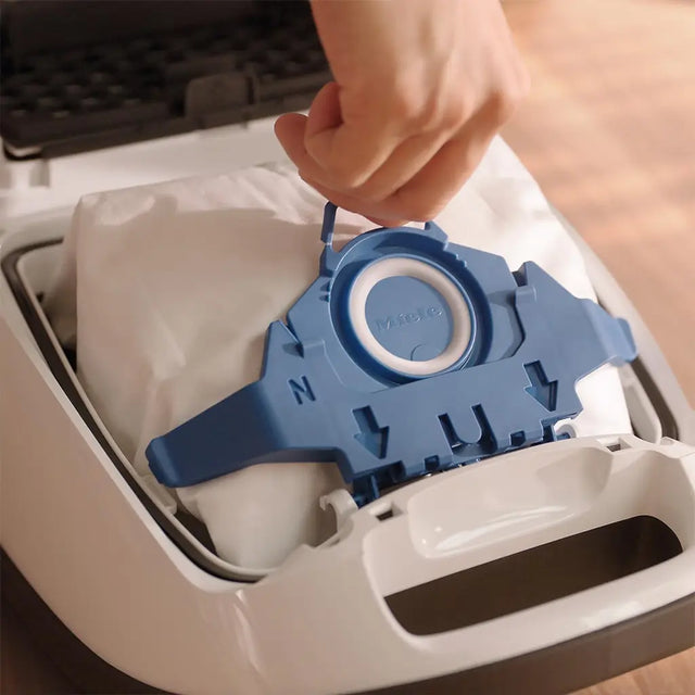 Blue cleaning tool being inserted into a washing machine