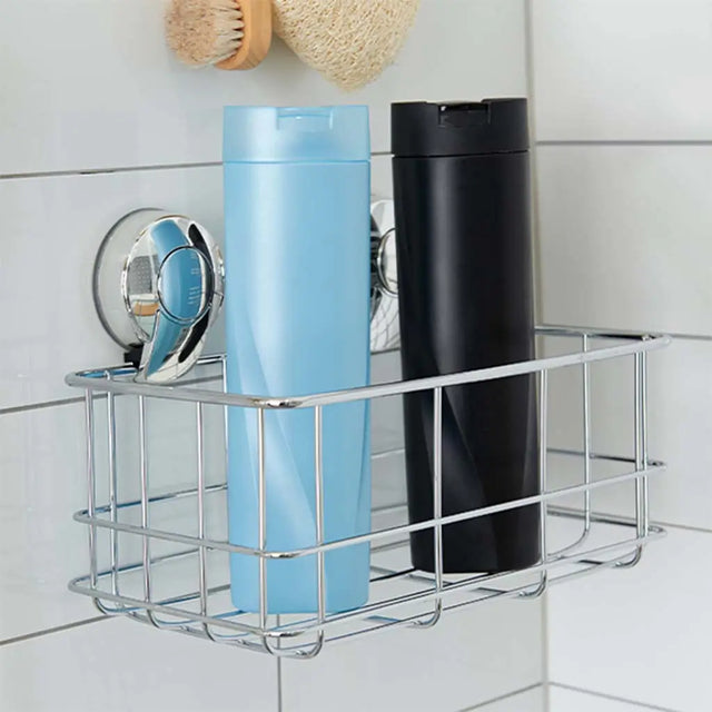 Metal shower caddy with blue and black bottles on a tiled shower wall.