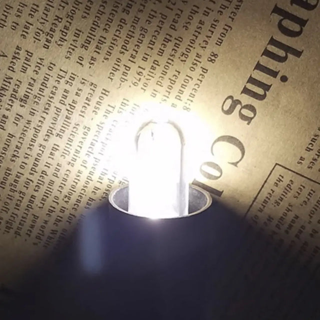 Light bulb on an open book with text in the background