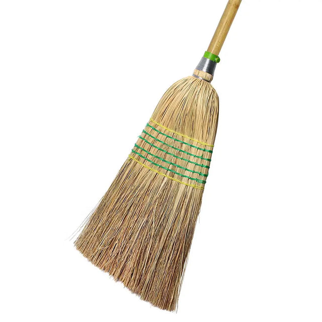 Broom with a wooden handle and straw bristles on a white background