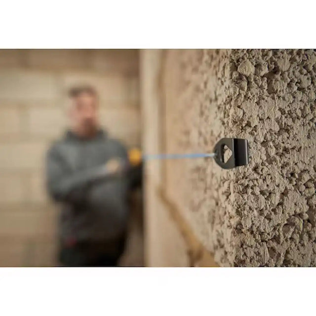 Stanley chalk line hook anchored to a masonry wall with line extended