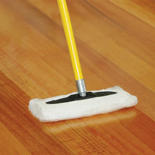Mop with a white pad and yellow handle cleaning a wooden floor.