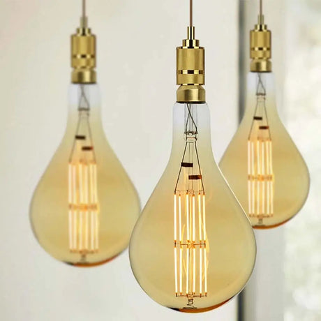Three vintage-style light bulbs with gold accents on a neutral background