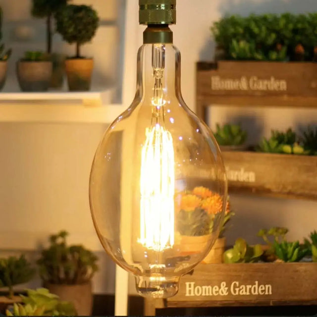 Vintage-style light bulb with a blurred 'Home & Garden' display in the background