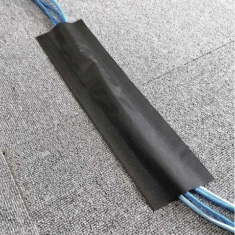 Black cable protector with blue cable on a textured gray surface