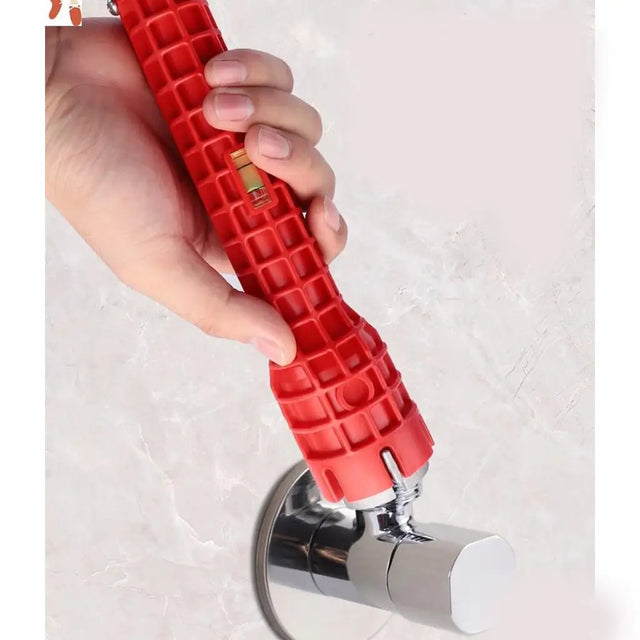 A hand holding a red plastic plumbing pipe coupler with a built-in level tool, positioned over a chrome wall-mounted faucet on a light marble-look tile wall.