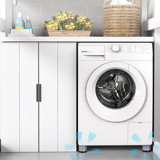 White washing machine in a laundry room with a cabinet and decorative items.