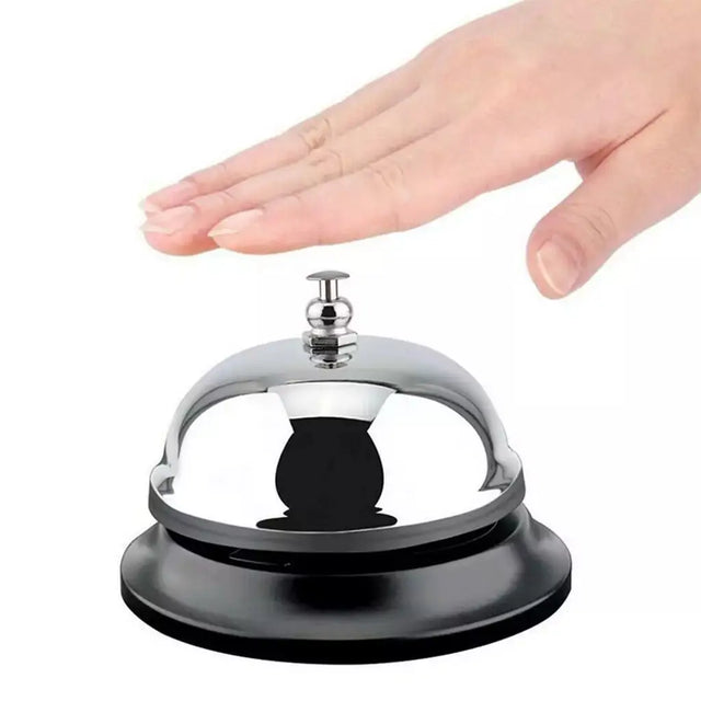 Hand pressing a black and silver service bell on a white background