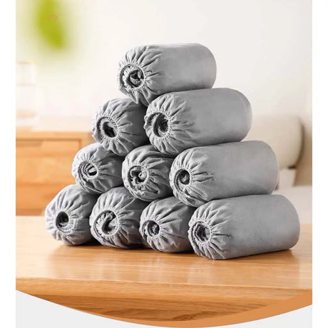 Stack of gray cylindrical pillows on a wooden surface with a blurred background
