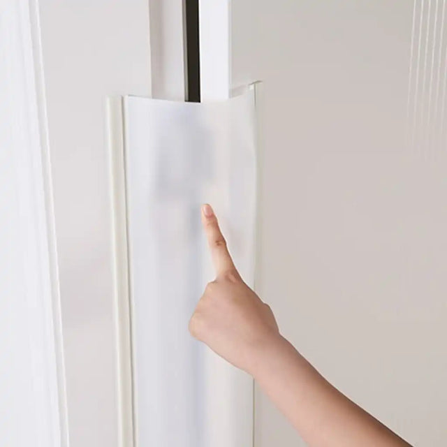 Hand opening a white door with a black handle on a light gray background