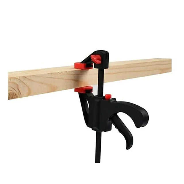 Black and red clamp holding a piece of wood on a white background