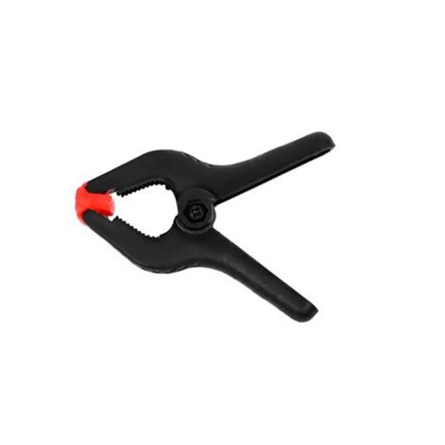 Black clamp with red button on a white background