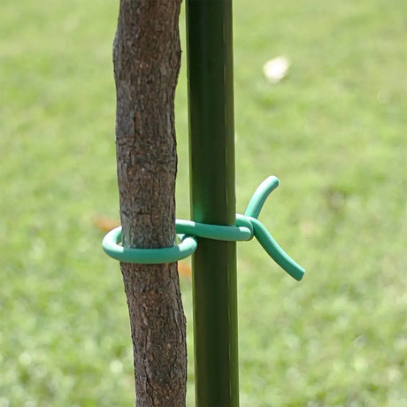 Green metal stake with a tree trunk and blurred green grass background