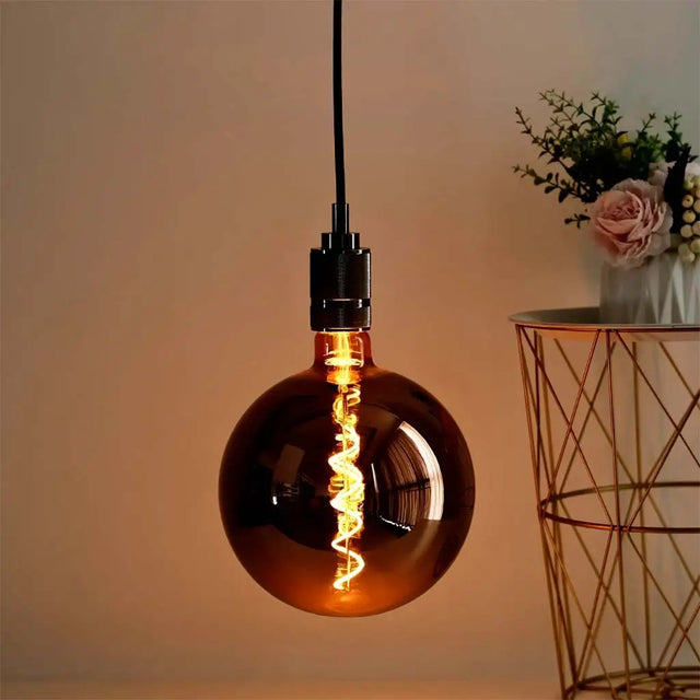 Decorative light bulb with a warm glow in a softly lit room.