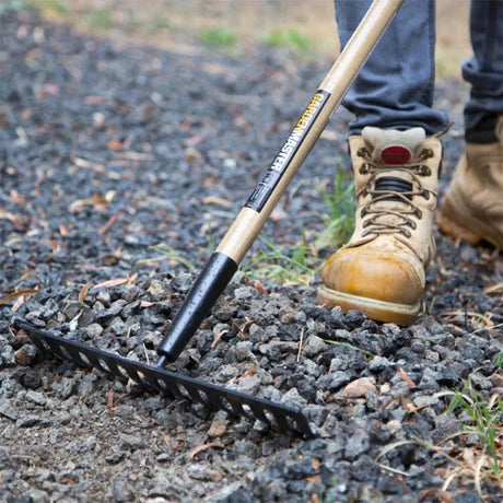 Person using a garden rake on a gravel surface with a close-up of the tool.