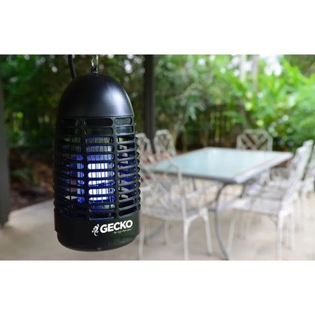 Black insect repellent lamp with 'Gecko' branding on a patio background