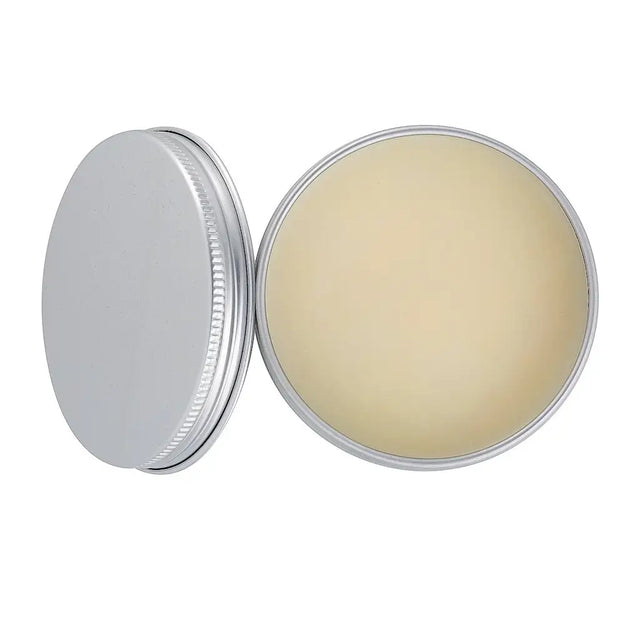 Round metal container with a silver lid and beige cream inside on a white background