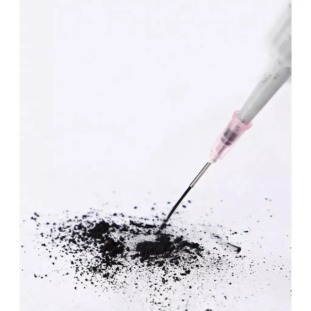 Syringe with black powder on a white background