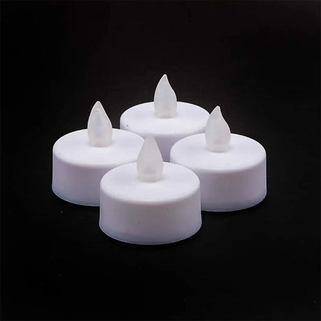 Four white LED candles with teardrop-shaped flames on a black background