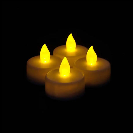 Four yellow LED candles on a black background