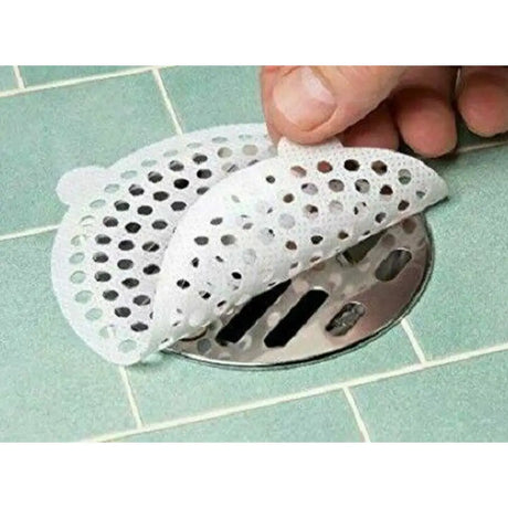 Hand placing a perforated white plastic drain cover over a metal drain.