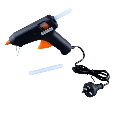 Black hot glue gun with orange trigger and power cord on a white background