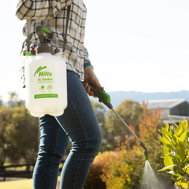 Person using a Hills SL Garden sprayer on plants outdoors