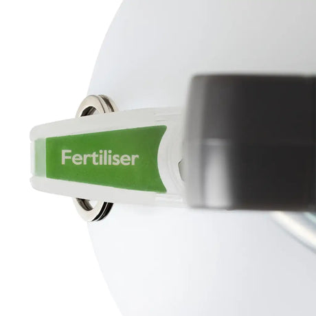 Close-up of a fertilizer applicator with a green label on a white background