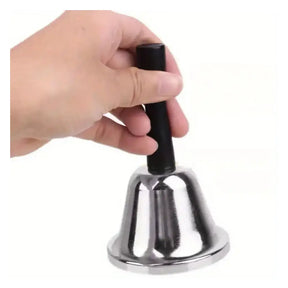 Hand holding a small silver bell with a black handle on a white background