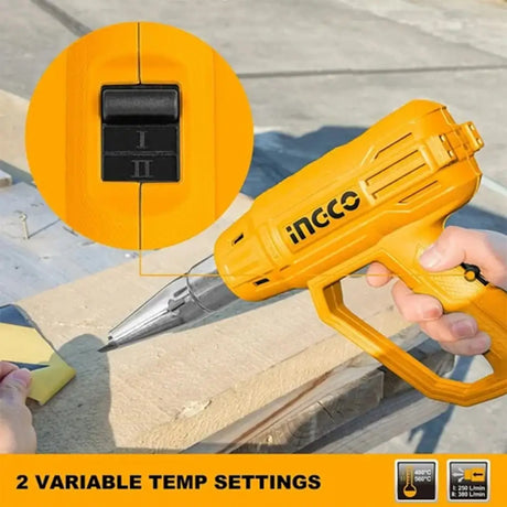 Yellow hot glue gun with temperature settings on a wooden surface