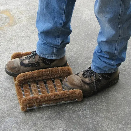Person using a metal grate with brown mat on a concrete surface