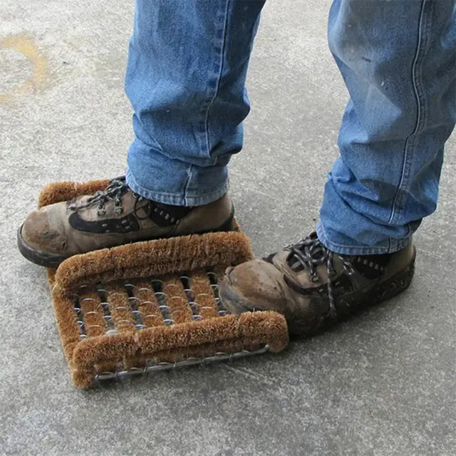 Person using a metal grate with brown mat on a concrete surface