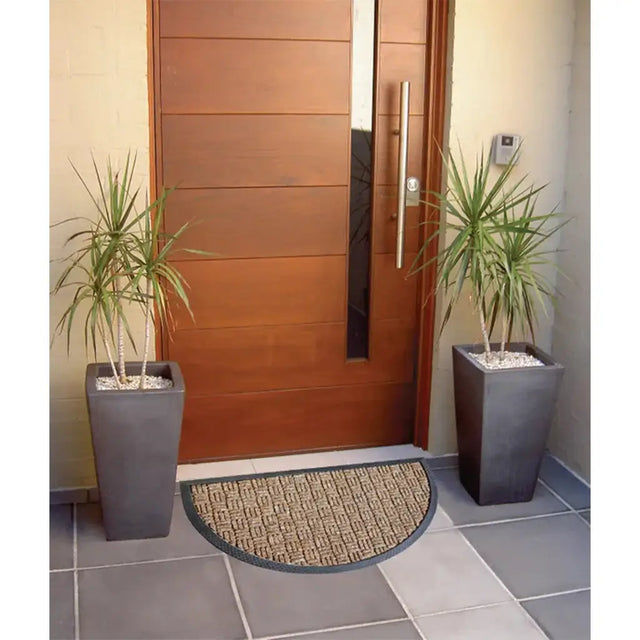 Modern wooden door with two potted plants and a doormat on a tiled floor.