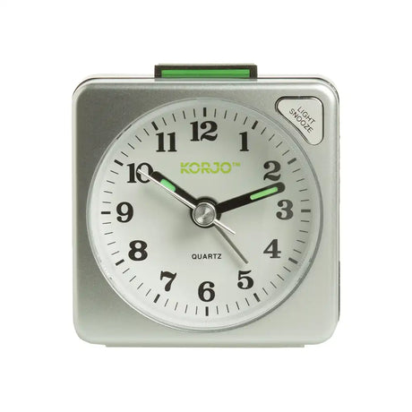 Silver alarm clock with white face and green accents on a white background