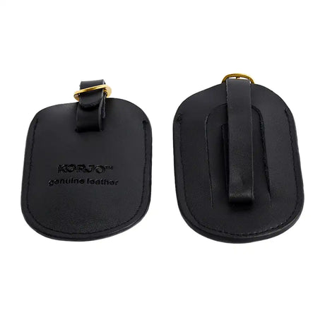 Two black leather luggage tags with gold hardware on a white background