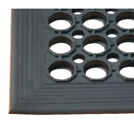 Close-up of a rubber mat with a textured surface and circular holes.