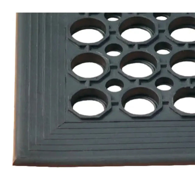 Close-up of a rubber mat with a textured surface and circular holes.