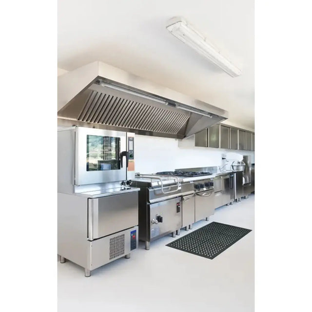 Commercial kitchen with stainless steel appliances and exhaust hood.