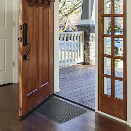 Open wooden front door leading to a porch with a white railing.