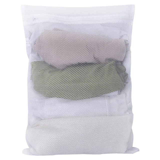 White mesh laundry bag with folded clothes inside on a white background
